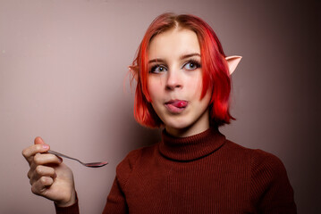 teenage girl with pink hair holding a teaspoon
