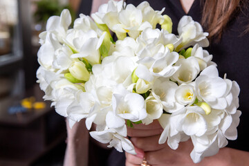 Close-up of bouquet of white freesia. Gift for women's Day. An image for flower shop, postcard. Selective focus.