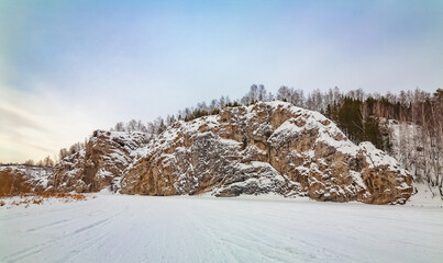 Fototapeta na wymiar Winter landscape with a large stone from a frozen river