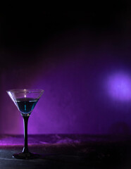 Blue cocktail in a tall glass. Against the background of neon light