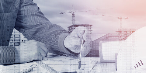 An engineer, an architect designs new buildings against the background of a construction site....