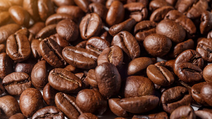 Freshly roasted coffee beans background.Dark roasted coffee beans with scoop on wooden background.