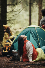 Woman camping with friends in a forest