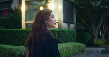 Confident asian businesswoman walking alone watching city architecture side view