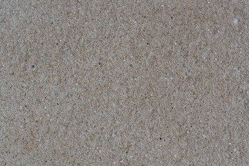 Textured wall made of granite chips, with a beautiful texture. The background is a wall of granite chips and cement mortar. The texture of the wall is made of granite chips and cement.
