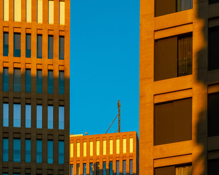 Edificios modernos de oficinas de ventanas rectangulares iluminados por la luz del sol del atardecer de la ciudad de la justicia.