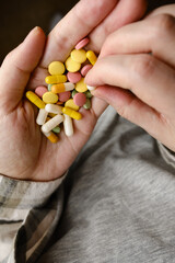 A hand holds an assortment of pills and vitamins close-up. Effective drugs, modern pharmacy for the body and mental health. The concept of healthcare, medicine, pharmacies, disease prevention