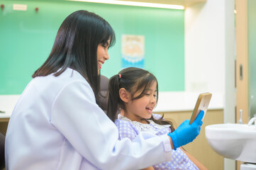 A little cute girl having teeth examined by dentist in dental clinic, teeth check-up and Healthy teeth concept