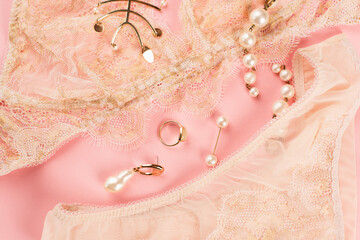 Top view of accessories near lace lingerie on pink background
