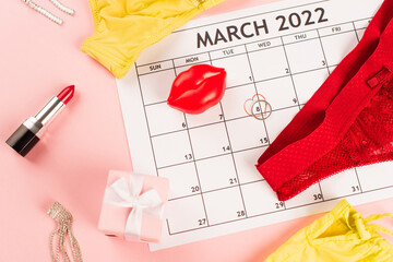 Top view of lingerie near present, march calendar and lipstick on pink background