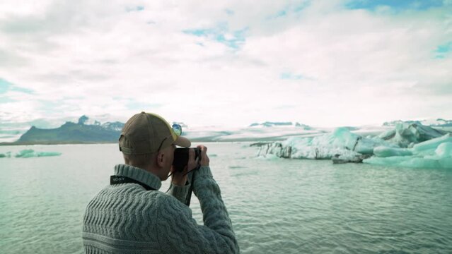 Man Taking Pictures Of Icebergs And Glaciers At Jokulsarlon Glacier In Iceland. - medium shot