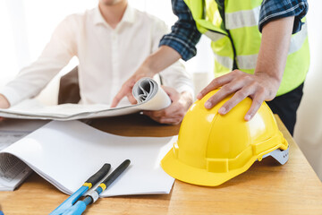 Close up hands of businessman from consultancy service discussing with project contractor and reviewing blueprint for build real estate facilities.