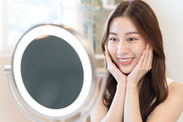 Close up young beautiful asian woman looking at mirror at home