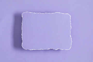 Piece of torn purple note with shadow. Torn, ripped paper on purple background. Blank purple paper...