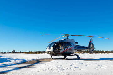 Isolated helicopter in snow landscape with clear blue sky