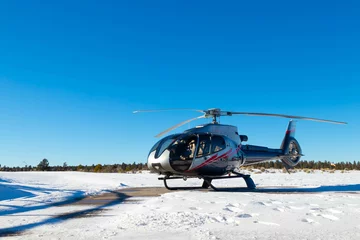 Rolgordijnen Helikopter Geïsoleerde helikopter in sneeuwlandschap met heldere blauwe lucht