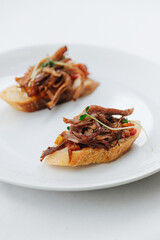 Bruschetta on a plate close up over white.