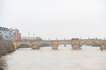 Basilica del Pilar in Zaragoza, and the stone bridge in northern Spain, on a cloudy day.