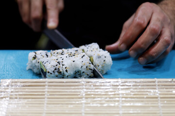 chef cortando sushi uramaki
