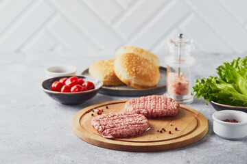 Raw veal mince Burger steak cutlets on wooden cutting board