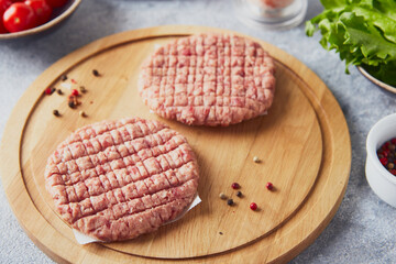 Raw veal mince Burger steak cutlets on wooden cutting board