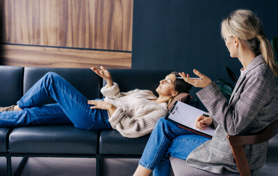 The psychoanalyst listens to and analyzes the story of a female patient lying on a couch.