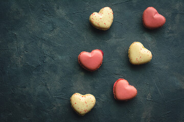 Obraz premium Macarons cakes in a shape of a heart. Small French cakes for Valentines Day. Sweet and colorful french macaroons.