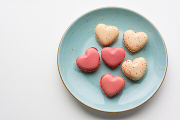 Macarons cakes in a shape of a heart. Small French cakes for Valentines Day. Sweet and colorful french macaroons.