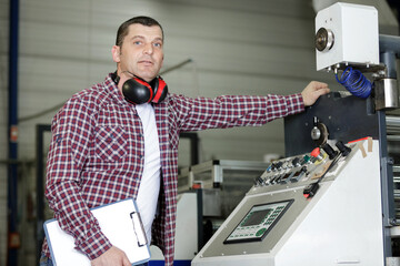 male operator operating industrial printing press