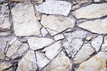 Stone texture. Dark grey and brownstone wall made of natural stone. Close-up. Rubble wall background.