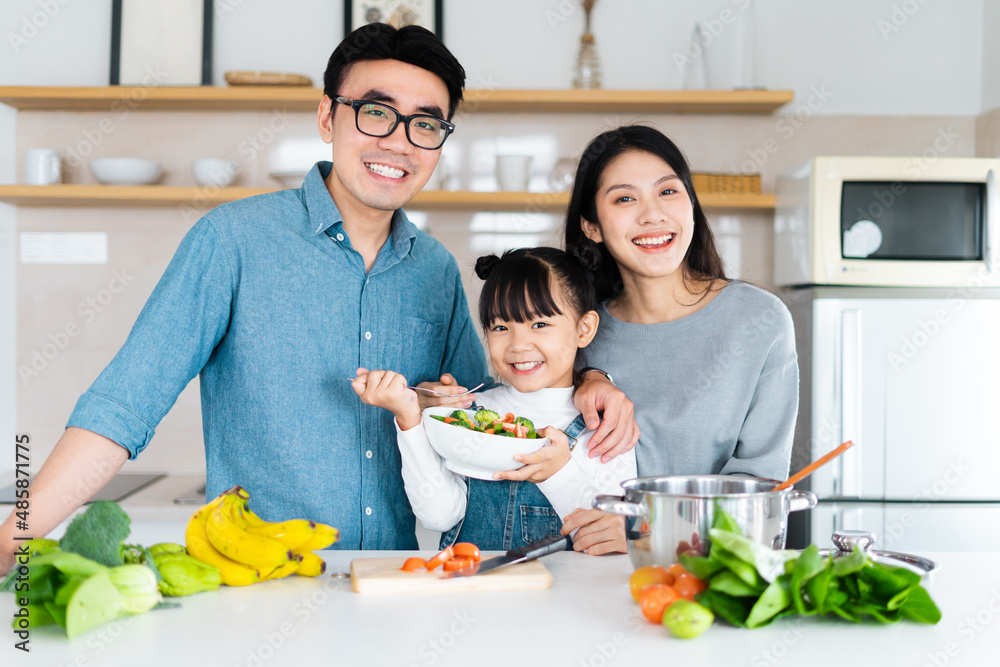 Wall mural image of an asian family cooking at home