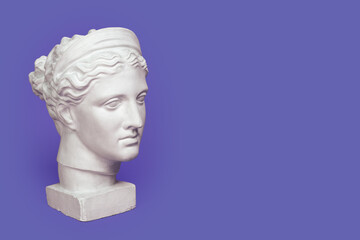Marble head of young woman, ancient Greek goddess bust isolated on violet background, very peri...