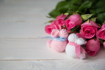 handmade pink and white bunnies with a bouquet of roses