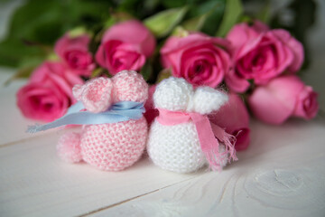 handmade pink and white bunnies with a bouquet of roses