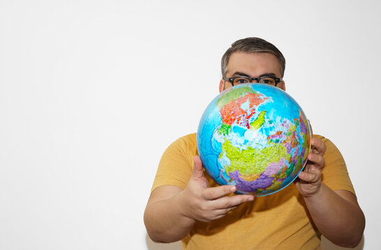 Portrait of handsome middle aged man holding globe map behind face.  knowledge tutor isolated on white background