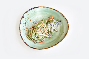 Asian wakame salad. Bowl on kitchen table. Modern dishes. Carrot, cucumber and mayonnaise dinner. Chuka herbs