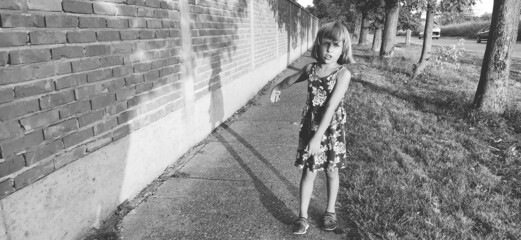 The girl walks along the road waving her arms. Black and white monochrome image. Decorated in retro...