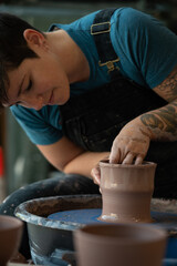 Fototapeta na wymiar Potter crafting a clay pot on a pottery wheel