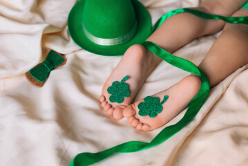 Children's feet and heels on a white bed to Saint Patrick's Day. Infant baby is sleeping in his crib. Importance of sleep for babies. Sleep mode babies 3 y.o.