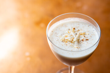 Eggnog rum cocktail with toasted coconut and nutmeg