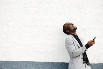 happy African american businessman laughing with mobile phone in hand