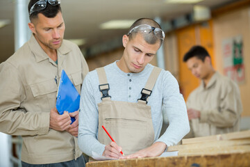carpenter supervising student in woodwork class
