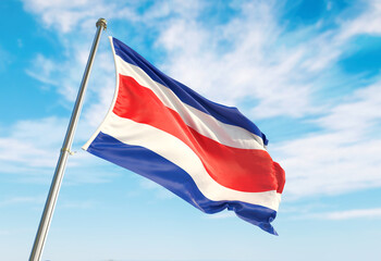 3d rendering Costa Rica flag waving in the wind on flagpole. Perspective wiev Costa Rica flag waving a blue cloudy sky