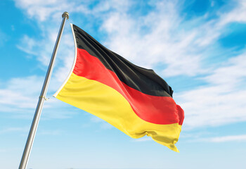 3d rendering Germany flag waving in the wind on flagpole. Perspective wiev Germany flag waving a blue cloudy sky