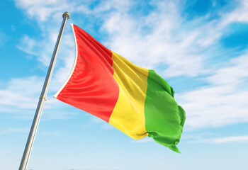 3d rendering Cameroon flag waving in the wind on flagpole. Perspective wiev Cameroon flag waving a blue cloudy sky