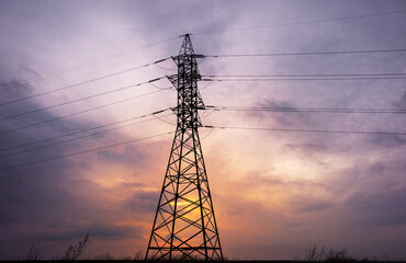 silhouette of power lines against the background of a cloudy sunset, saturated sky and pylons