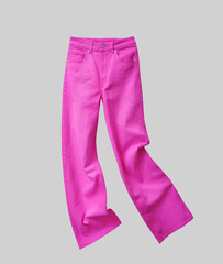 Fuchsia color jeans isolated on gtey. Pink womens fashion pants.