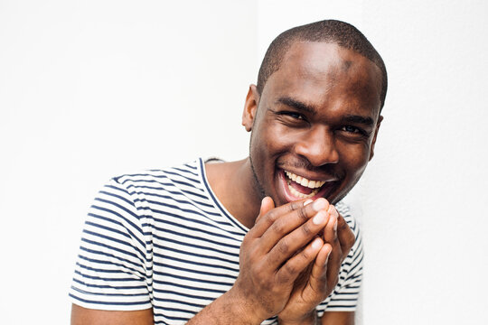 Close Up Laughing African Man With Hands By Face Against Isolated White Background