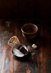 Bamboo tea whisk on rustic wooden background. 