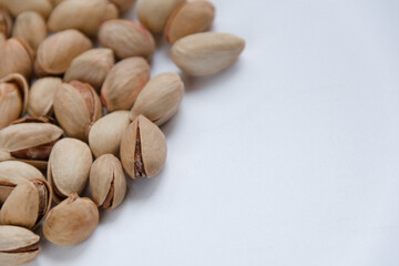 Roasted salted pistachios in a basket, plate on a white background